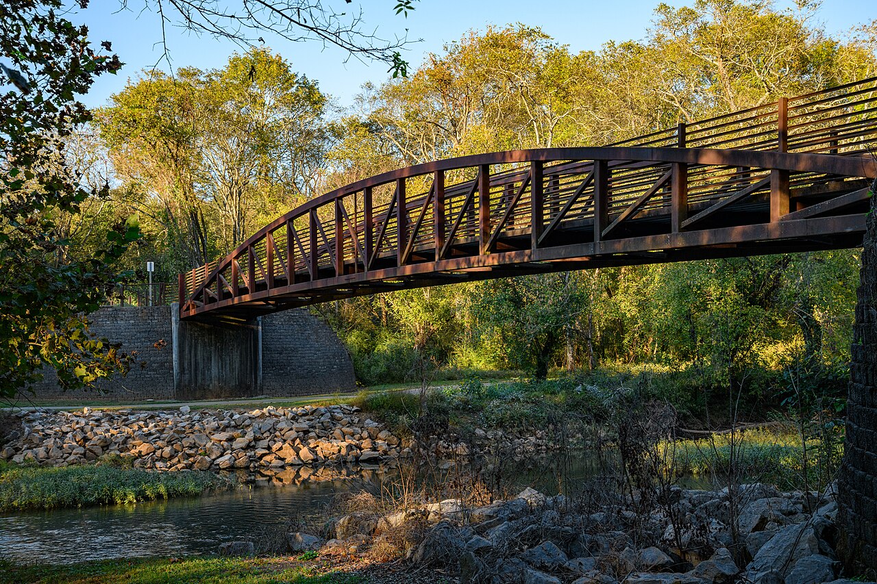 A railed bridge crossing above the Flint River and its rocky banks at Hays Nature Preserve.